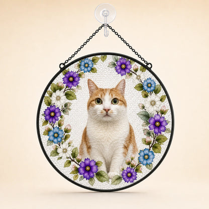 Round hanging decorative sign featuring a white and orange cat centered within a floral wreath of purple, blue, and white flowers, suspended by a black chain from a clear wall hook against a warm beige background.